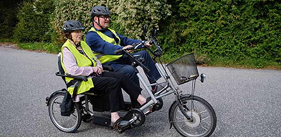 Frivillig cykler en tur med en beboer på plejecenter